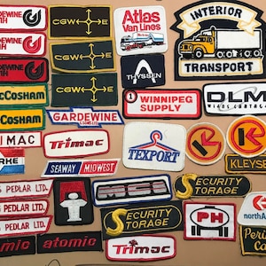 Może przedstawiać: Kolekcja vintage haftowanych naszywek z różnymi logotypami firm, w tym "Gardewine North", "Atlas Van Lines", "Interior Transport", "MacCosham", "Trimac", "Winnipeg Supply", "DLM Wiens Cartage", "Texport", "Fleming Pedlar LTD.", "Security Torage", "Kleysen's", "North American" i "Perimeter Cargo".