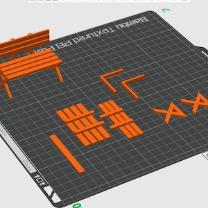 May include: Orange plastic 3D printed objects on a gray textured surface. The objects include a bench, a set of small rectangular blocks, and a set of geometric shapes.