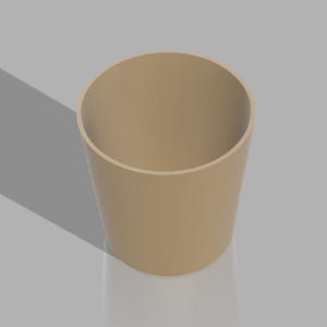 May include: A tan-colored, cylindrical container with a smooth surface. The open top reveals the hollow interior. The object is set against a light gray background, with a shadow cast to the left.