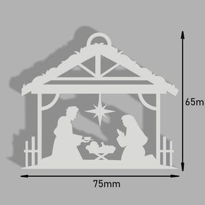 Peut inclure: Découpe en papier blanc d'une scène de la nativité avec une étoile au-dessus de la crèche. La scène mesure 75 mm de large et 65 mm de haut.