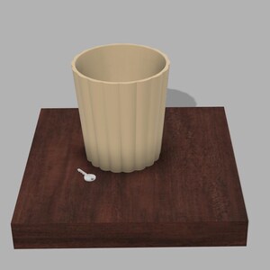 May include: A beige ceramic cup with a ribbed design sits on a dark brown wooden surface. A small white key is lying on the surface.