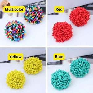 Pode incluir: Quatro pares de brincos de contas coloridas. Os brincos são redondos e feitos de contas pequenas. As cores são multicoloridas, vermelho, amarelo e azul.