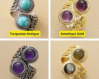 May include: Four rings with different gemstones and settings. The rings are all gold or silver and have a vintage style. The gemstones are turquoise, amethyst, labradorite, and amethyst. The rings are all on a white background.