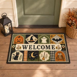 May include: A rectangular doormat featuring a patchwork design with Halloween motifs including a jack-o'-lantern, witch hat, ghost, bat, black cat, crescent moon, broom, and owl. The center horizontal panel displays the word WELCOME in black.