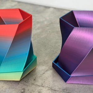 May include: Two 3D printed planters, one in a gradient of red, blue, and green, and the other in a gradient of purple, blue, and green.