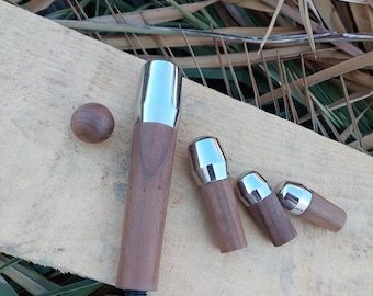 Pode incluir: Um conjunto de pernas de móveis de madeira com tampas de metal polido. As pernas variam em tamanho e forma, com uma pequena bola de madeira e uma perna maior com base roscada. A madeira tem um tom castanho quente.