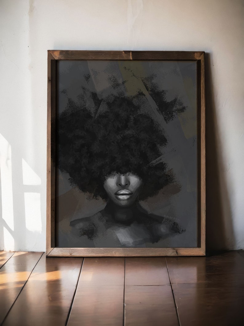 Puede incluir: Una impresi&oacute;n art&iacute;stica enmarcada que presenta un retrato en escala de grises de una persona con un afro grande y texturizado. La obra de arte est&aacute; sobre un fondo oscuro y abstracto y enmarcada en madera oscura. Los labios de la persona est&aacute;n resaltados.