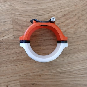 May include: A white, black, and orange plastic bike mount with a screw on the top.