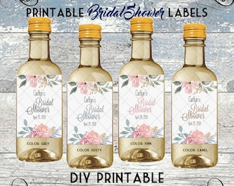 May include: Four printable mini wine bottle labels with a floral design and the text "Caitlyn's Bridal Shower" and the date "April 29, 2019". The labels are in four different colors: grey, dusty rose, pink, and camel.