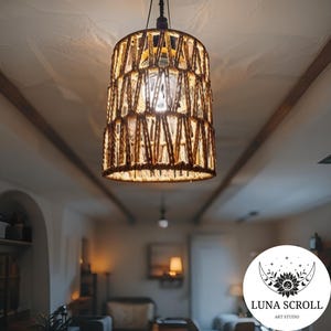 Puede incluir: Una lámpara colgante cilíndrica con una pantalla de cuerda marrón tejida. La luz cuelga del techo e ilumina la habitación. Adecuada para una sala de estar o comedor, creando un ambiente cálido y acogedor.
