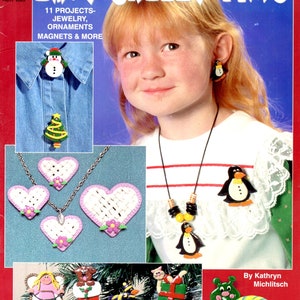 May include: A craft book titled Easy Breezy Fimo by Kathryn Michlitsch featuring 11 projects including jewelry, ornaments, and magnets. The cover displays various clay items like a snowman pin, heart necklaces, penguin jewelry, and a snail figure.