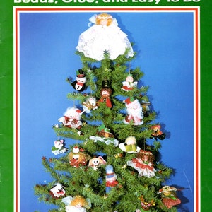 May include: A craft book titled Little Tree Ornaments: Beads, Glue, and Easy To Do, Book 293. The cover features a green Christmas tree decorated with various small, handmade doll-like ornaments, including angels, animals, and figures.