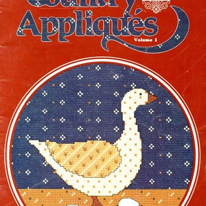 May include: A vintage book cover titled "Country Appliqués Volume 1" with a red background. The cover features a cross-stitch design of a white goose with yellow and brown accents, surrounded by a blue dotted circle and three white eggs.