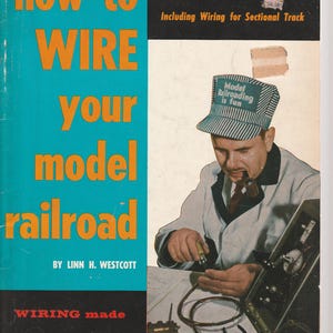 May include: A book cover titled "How to Wire Your Model Railroad" with a teal background and orange text. The cover features a man in a lab coat and a hat that says "Model Railroading is fun". The book is the 5th edition.