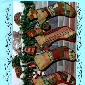 May include: A pattern sheet titled Perennial Blessings by Marlene Troyer Ps 16:11 and A Pieceful Christmas featuring four patchwork Christmas stockings made from various plaid and solid fabric scraps, hanging on a green garland.
