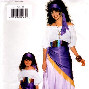 May include: A sewing pattern envelope for Butterick 4653 featuring a white off-the-shoulder blouse, a purple and light purple skirt with gold fringe, a matching purple sash, and a headscarf. The pattern includes sizing charts for bust, waist, and hip measurements.