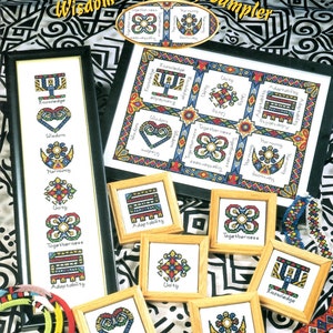 May include: A cross-stitch sampler titled "Wisdom & Harmony" featuring framed needlework pieces. The main sampler is framed, with additional smaller framed pieces. The design includes symbols and the words "Knowledge," "Wisdom," "Harmony," "Unity," "Togetherness," and "Adaptability."