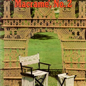 May include: A vintage magazine cover titled "Mad About Macrame, No. 2" featuring a macrame archway, chair, and stool. The chair and stool have black frames and white fringed fabric. The archway is made of knotted rope.