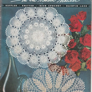 May include: A vintage J. & P. Coats Clark's O.N.T. Doilies in the Modern Manner Book No. 297 pattern booklet. The cover features two white crocheted doilies, a dark teal glass vase, and a cluster of red roses against a dark teal background.