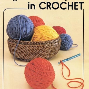 May include: A book cover titled "First Steps in CROCHET" by Mary Thomas. The image features a woven basket filled with blue, red, and yellow yarn balls. A crochet hook and a ball of red yarn are also visible.