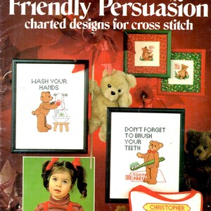 May include: Cover of a cross-stitch pattern booklet titled "Friendly Persuasion." The cover features framed cross-stitch designs with teddy bears and text like "Wash Your Hands" and "Don't Forget to Brush Your Teeth."