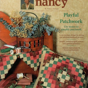 May include: A book cover titled "Sewing with Nancy" features a woman's portrait and a basket of flowers. The book promotes "Playful Patchwork" with instructions for quilt projects. Pillows and fabric scraps with patchwork designs are displayed.