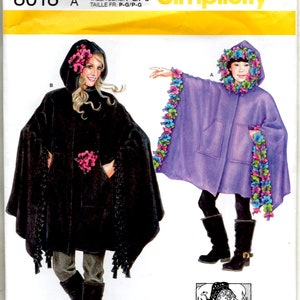 May include: Simplicity pattern 8018 A features two hooded cape designs. One cape is black with pink floral accents, and the other is purple with colorful floral trim. The pattern includes sizes S-L.
