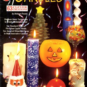 May include: A book cover titled "Basic Steps to Candles" featuring various lit candles in different shapes and designs, including a Christmas tree, a Jack-o'-lantern, and a Santa Claus. The cover also includes text about candle-making techniques.