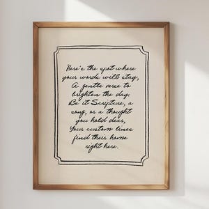 May include: A rectangular wall art print in a light wood frame featuring black cursive text on a cream background. The text reads: Here's the spot where your words will stay, A gentle verse to brighten the day. Be it Scripture, a song, or a thought you hold dear, Your custom lines find their home right here.