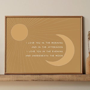 May include: A brown framed print with a beige background and white text that reads "I love you in the morning and in the afternoon. I love you in the evening and underneath the moon." The print features a sun and a crescent moon.