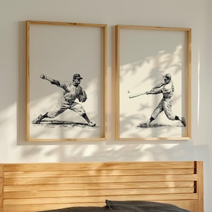 May include: Two framed vintage baseball art prints. One shows a pitcher in motion, the other a batter swinging. The prints are black and white illustrations in light wood frames, displayed above a wooden headboard.
