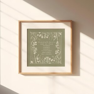 K&ouml;nnte beinhalten: Ein quadratisches gerahmtes Wandbild mit salbeigr&uuml;nem Hintergrund und wei&szlig;em Blumenrand. Der mittige Text lautet: The fruit of the Spirit is LOVE JOY PEACE PATIENCE KINDNESS GOODNESS FAITHFULNESS GENTLENESS SELF CONTROL.