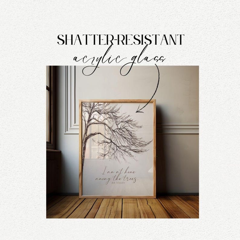 May include: A framed print with a black and white drawing of a tree with the quote "I am at home among the trees." by  R.W. Emerson. The frame is made of wood and has a light brown finish. The print is on shatter-resistant acrylic glass.