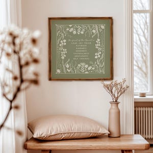 K&ouml;nnte beinhalten: Ein quadratisches Wandbild in einem dunklen Holzrahmen mit salbeigr&uuml;nem Hintergrund, wei&szlig;en botanischen Illustrationen und dem Text: The fruit of the Spirit is LOVE, JOY, PEACE, PATIENCE, KINDNESS, GOODNESS, FAITHFULNESS, GENTLENESS, SELF CONTROL.