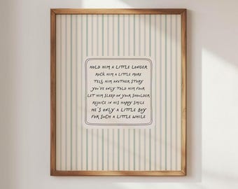 May include: A framed print with a light brown wooden frame. The artwork features a striped background in white and pale green. The text in the center reads: "HOLD HIM A LITTLE LONGER...HE'S ONLY A LITTLE BOY FOR SUCH A LITTLE WHILE."