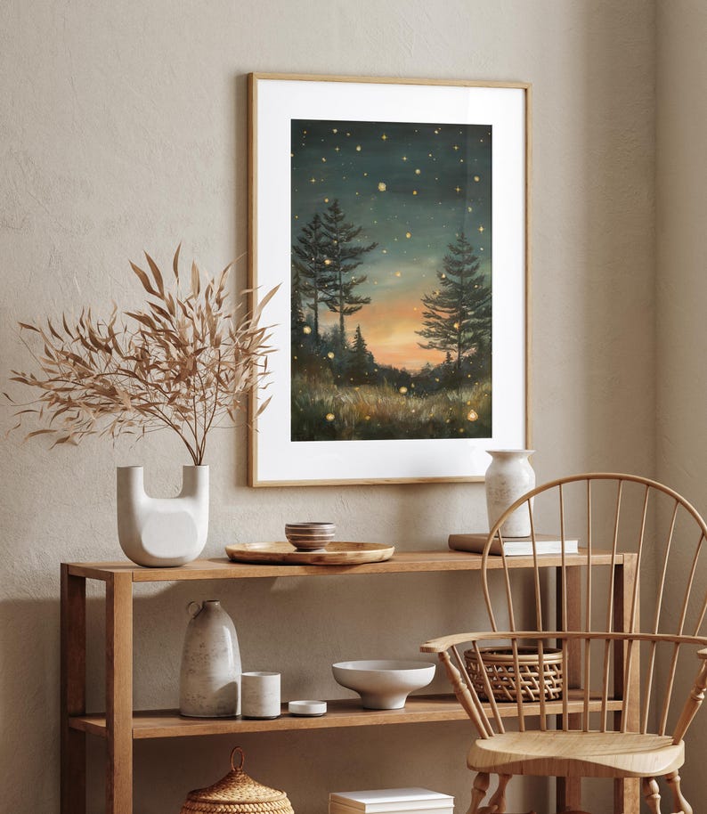 Puede incluir: Una pintura enmarcada que representa una escena de bosque nocturno con dos &aacute;rboles altos y un cielo estrellado. La pintura est&aacute; en un marco de madera claro y est&aacute; colgada en una pared.