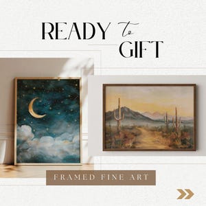May include: Two framed fine art prints, ready to gift. The first print features a crescent moon and stars against a dark blue sky with white clouds. The second print depicts a desert landscape with tall cacti and a dirt path leading into the distance.