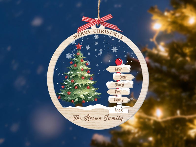 May include: A round wooden Christmas ornament featuring a green tree with red stars, a signpost with the names Kevin, Dinah, Sidney, Rose, and Hubery, and the text Merry Christmas, 2025, and The Brown Family, topped with a red gingham bow.