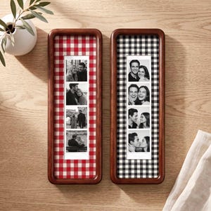 Puede incluir: Dos marcos de fotos rectangulares verticales de madera con esquinas redondeadas. Un marco tiene un fondo de tela de cuadros vichy rojos y blancos, y el otro de cuadros vichy negros y blancos. Cada uno contiene una tira de cuatro fotos en blanco y negro.