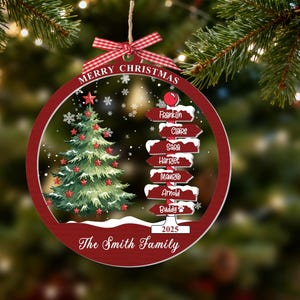 May include: A round, red-bordered Christmas ornament featuring a green tree with red stars, a signpost with names Franklin, Claire, Sara, Harriet, Maurice, Arnold, and Buddy, the text Merry Christmas, 2025, and The Smith Family, topped with a red plaid bow.