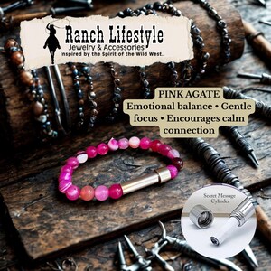 May include: A pink agate bracelet with a silver clasp, displayed on a wooden surface. The bracelet is made of round, pink beads. The image includes text that reads "Ranch Lifestyle Jewelry & Accessories" and "Pink Agate". A secret message cylinder is also shown.