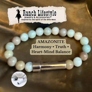 Może przedstawiać: Bransoletka z koralików amazonitu ze srebrnym zapięciem. Bransoletka ma jasnozielone i beżowe koraliki. Tekst na zdjęciu brzmi "AMAZONITE Harmony • Truth • Heart-Mind Balance" oraz "Ranch Lifestyle Jewelry & Accessories".