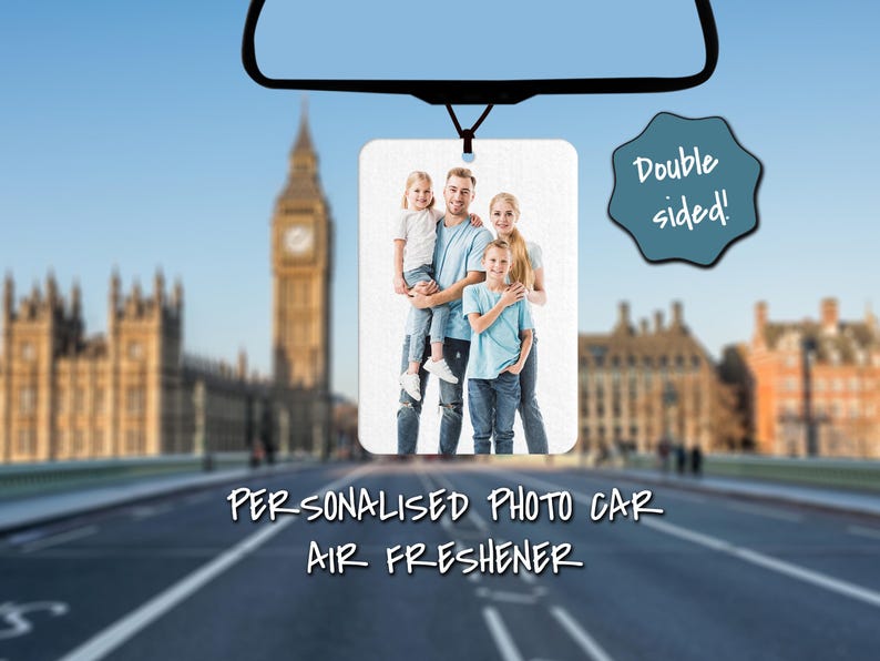 May include: A white photo car air freshener with a family of four in a photo. The photo shows a man holding a young girl in his arms, a young girl standing next to him, and a young boy standing in front of him. The text "Double sided!" is in a blue circle on the right side of the image. The text "Personalised Photo Car Air Freshener" is below the image.