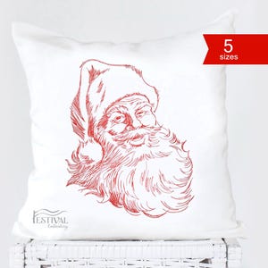 May include: Red line drawing of Santa Claus's face on a white cushion. The cushion is on a white wicker surface. The text "5 sizes" is in red on a white banner.