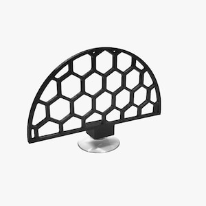 Op de afbeelding: Een zwart, halfrond decoratief object met een honingraatpatroon. Het object is gemonteerd op een kleine, vierkante basis en een doorzichtige, cirkelvormige zuignap. Het ontwerp is modern en geometrisch.