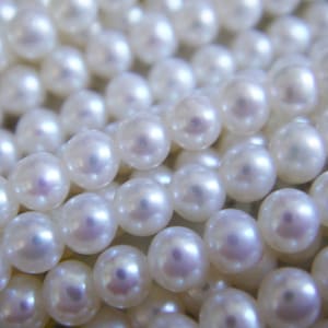 Pode incluir: Um fio de pérolas brancas, uma peça de joalheria clássica e elegante.