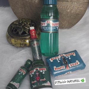Puede incluir: Un conjunto de botellas verdes y azules y una pastilla de jabón con el texto "Bint El Sudan" y "Beauty Soap". Las botellas están etiquetadas con "Eau de Cologne" y "Polvo".