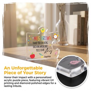 May include: A clear acrylic puzzle piece with the text "MS BROWN THANK YOU FOR BEING SUCH AN IMPORTANT PIECE OF MY story Sophia". The piece has a red apple, a pencil, a book, and a clock graphic. The text "An Unforgettable Piece of Your Story" is also visible.