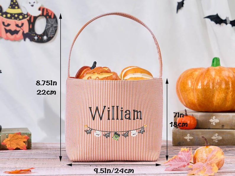 Puede incluir: Un bolso tote con tem&aacute;tica de Halloween, de 22 cm de alto y 24 cm de ancho, con un dise&ntilde;o a rayas rojas y blancas. La bolsa presenta el nombre "William" y una pancarta con iconos de Halloween. Contiene calabazas decorativas.