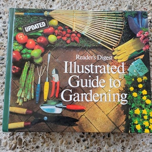Puede incluir: Una guía ilustrada actualizada para la jardinería de Reader's Digest. La portada presenta una variedad de herramientas de jardinería, plantas y flores, incluyendo un rastrillo, una pala, un par de tijeras de podar, espárragos, tomates y caléndulas.